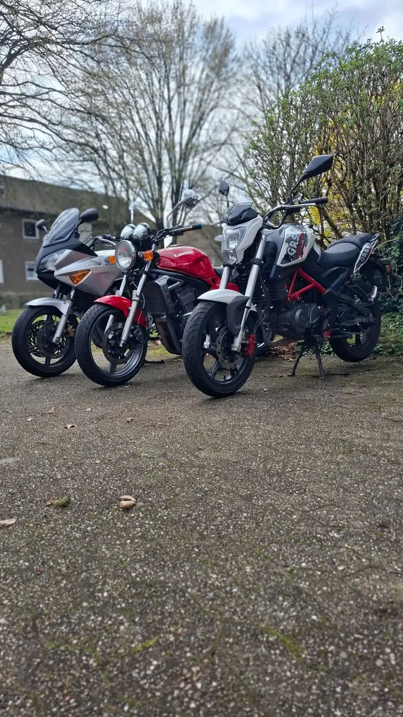 Die drei Schulmotorräder der Fahrschule Steinhoff diagonal nebeneinander: Honda, Kawasaki und KSR